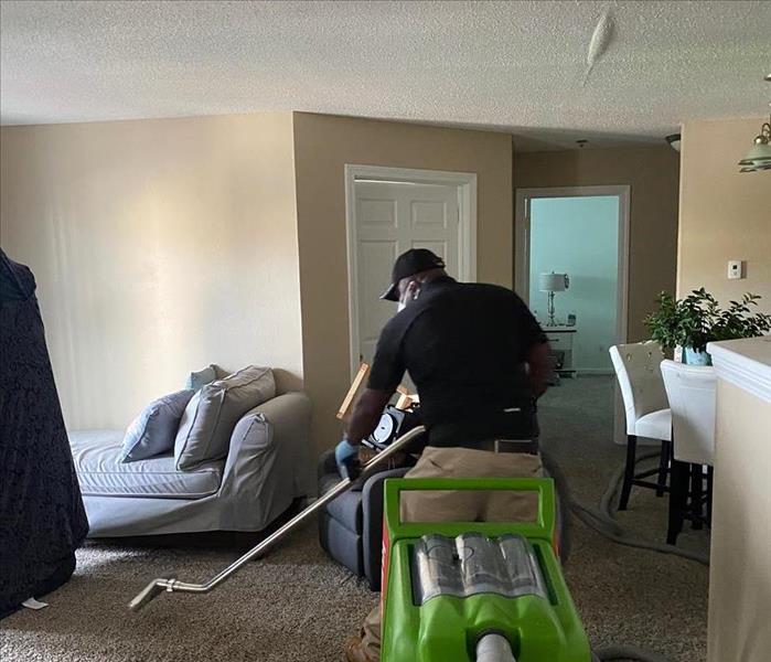 A man cleaning carpet in a room